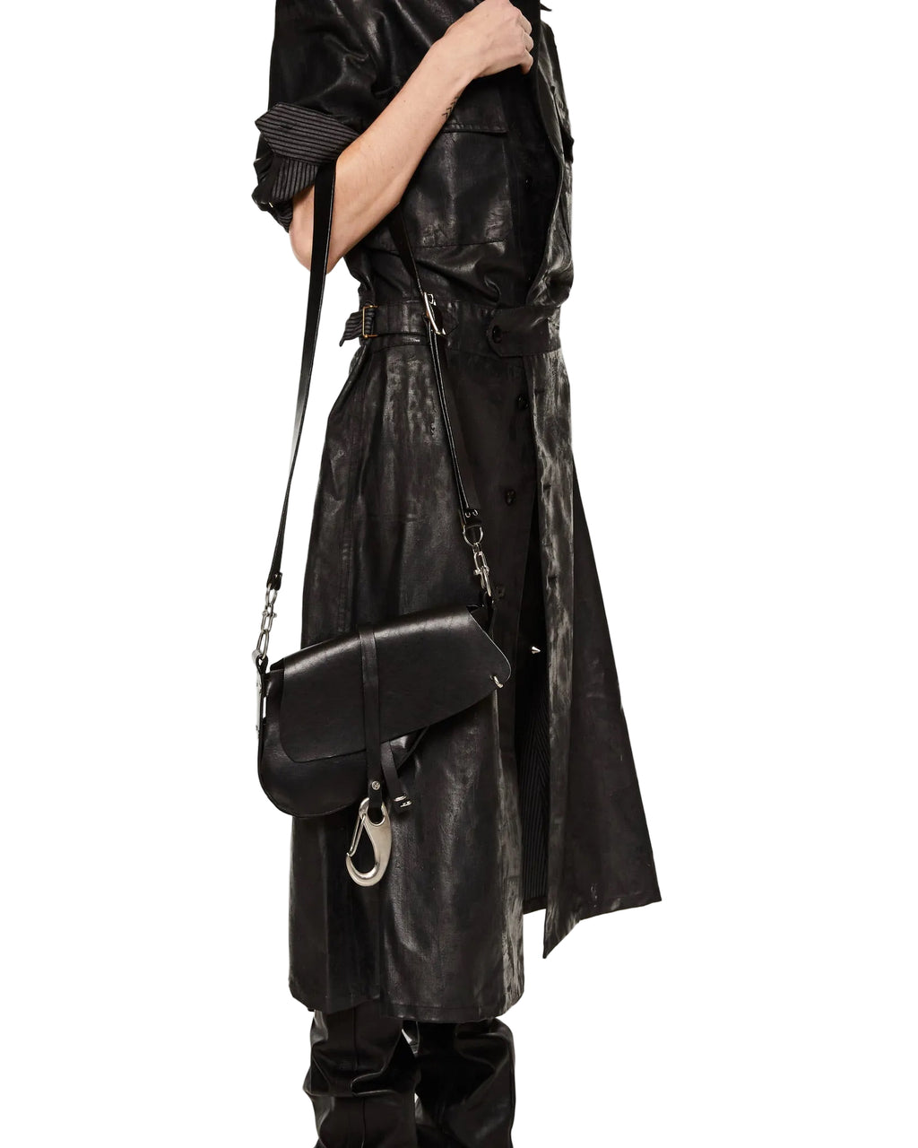 Person wearing a black leather trench coat holding a matching black handbag on a white background