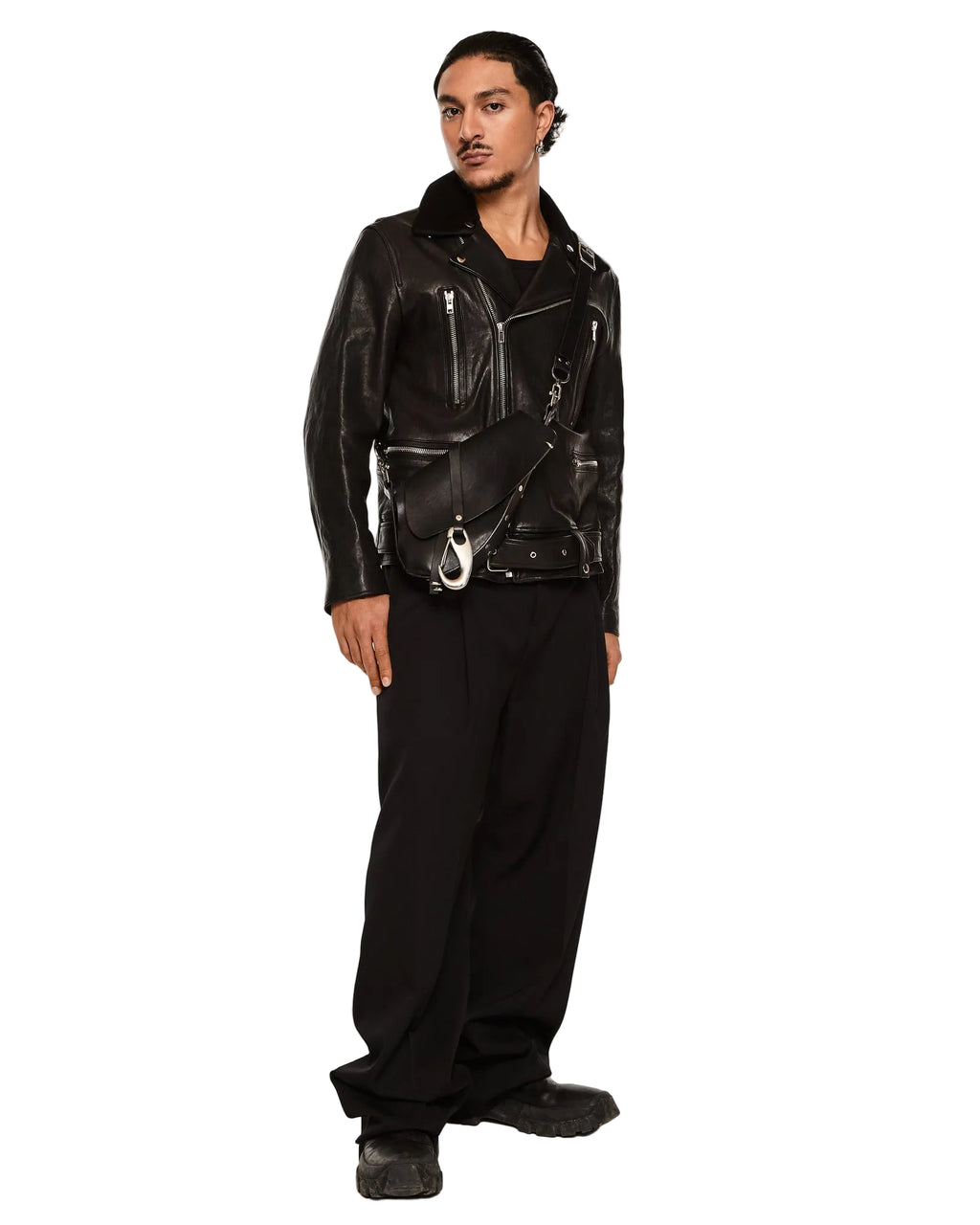 Person wearing a black leather jacket and pants on a white background