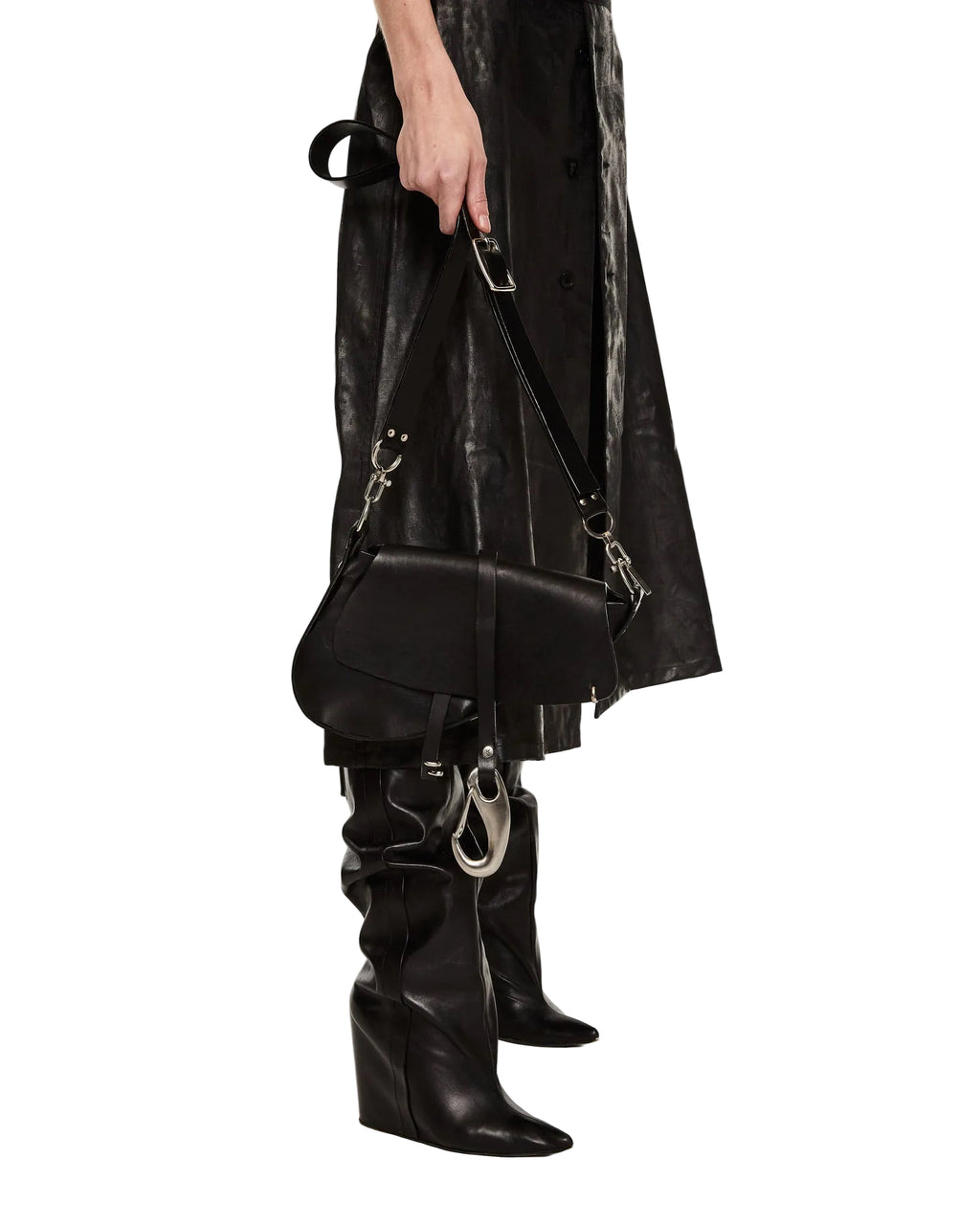 Person wearing a black leather outfit with a matching bag and boots on a white background